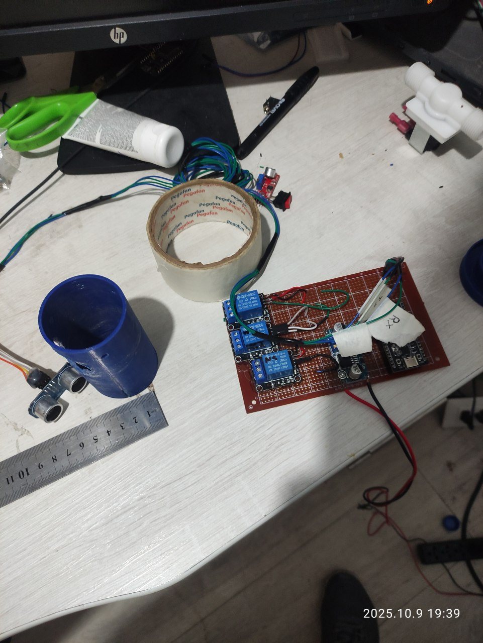 Prototipo sobre la mesa de trabajo: placa con relés, ESP32, sensor ultrasónico y piezas impresas en 3D
